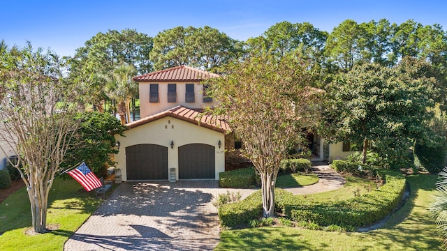 mediterranean / spanish house with a front lawn and a garage