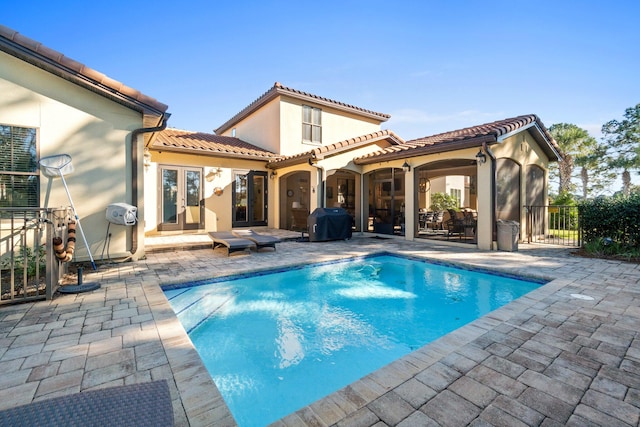 view of swimming pool with a grill, a patio area, and french doors