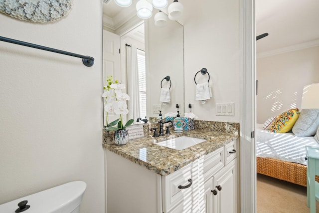 bathroom featuring toilet, vanity, and ornamental molding