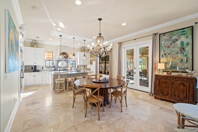 dining space with french doors, crown molding, and a notable chandelier