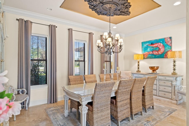 dining space with ornamental molding, a raised ceiling, and a notable chandelier