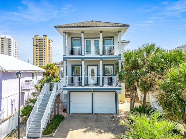 raised beach house with a porch, a garage, and a balcony