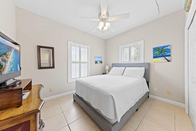 bedroom featuring ceiling fan, a closet, light tile patterned floors, and multiple windows