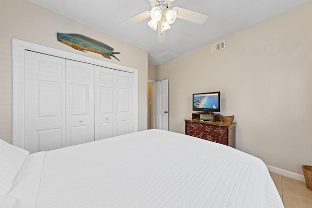 tiled bedroom featuring ceiling fan and a closet