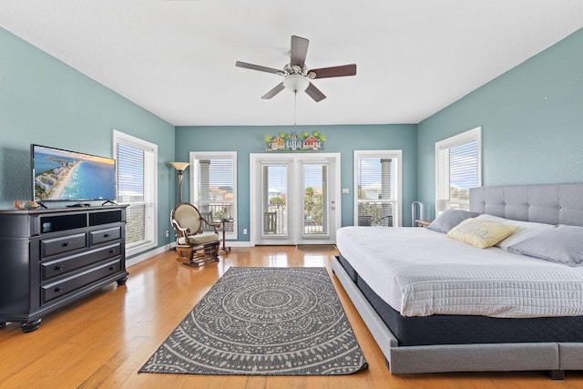 bedroom with access to exterior, light hardwood / wood-style flooring, multiple windows, and ceiling fan