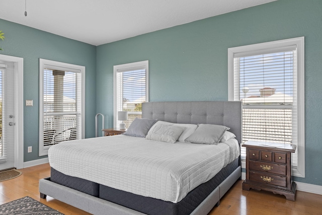 bedroom featuring access to exterior and hardwood / wood-style floors