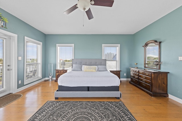 bedroom featuring access to exterior, light hardwood / wood-style floors, and ceiling fan