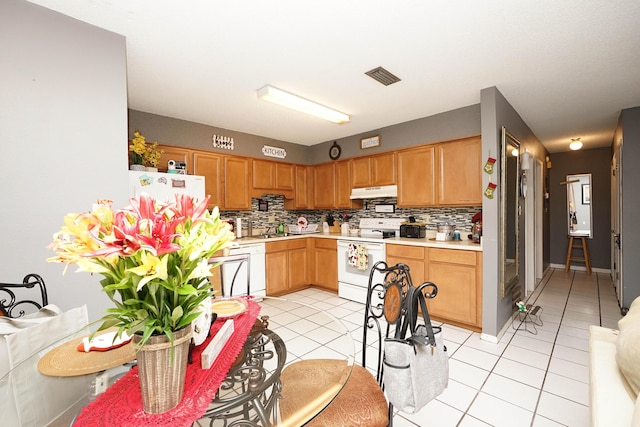 kitchen featuring white appliances, sink, light tile patterned floors, and tasteful backsplash