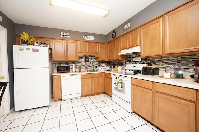 kitchen with light tile patterned flooring, white appliances, and backsplash