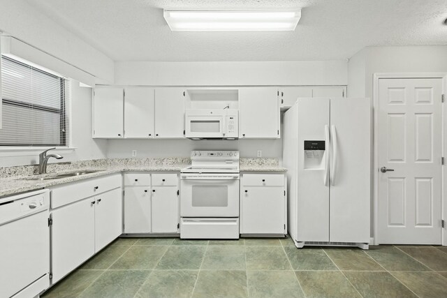 kitchen featuring white cabinets, a textured ceiling, white appliances, and sink