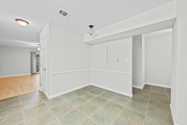 unfurnished room featuring ceiling fan, hardwood / wood-style floors, and a textured ceiling