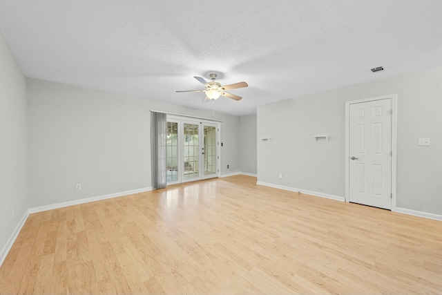 spare room with ceiling fan, light wood-type flooring, and a textured ceiling