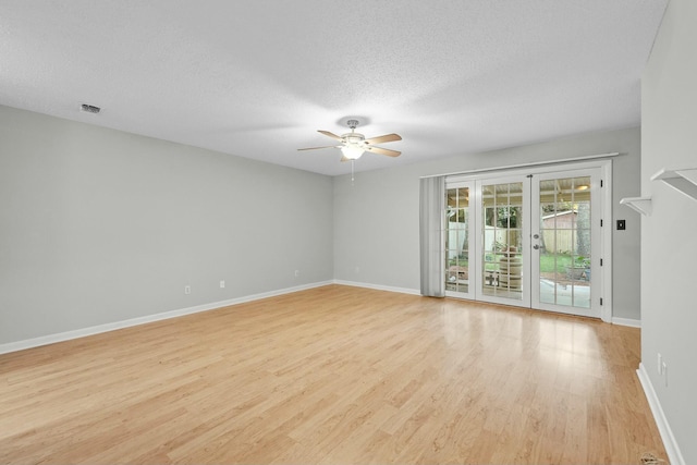 unfurnished room featuring ceiling fan, light hardwood / wood-style floors, a textured ceiling, and french doors