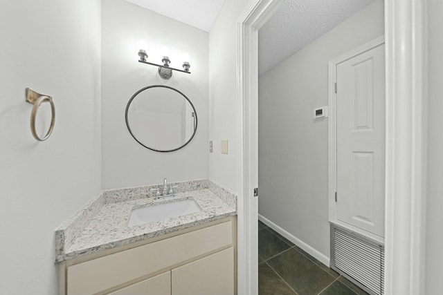 bathroom with tile patterned flooring, vanity, and a textured ceiling