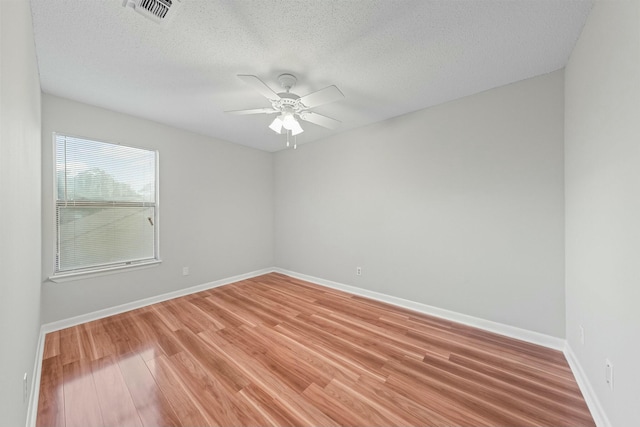 spare room featuring hardwood / wood-style floors, ceiling fan, and a textured ceiling