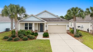 view of front facade featuring an attached garage, a porch, concrete driveway, and a front lawn