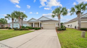 view of front of home with a front yard, an attached garage, and concrete driveway