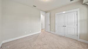 unfurnished bedroom featuring carpet, baseboards, and a closet