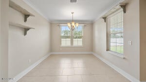 unfurnished dining area featuring light tile patterned floors, visible vents, baseboards, and crown molding