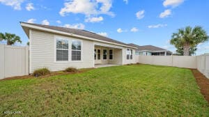 back of house featuring a yard and a fenced backyard