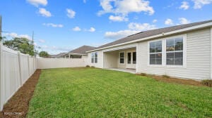 rear view of property featuring a fenced backyard, a patio area, and a yard