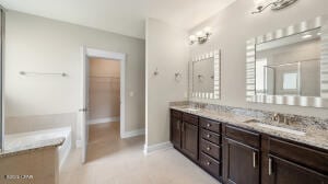 bathroom featuring baseboards and double vanity