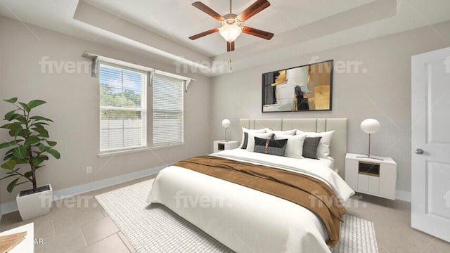 bedroom with tile patterned flooring, ceiling fan, baseboards, and a tray ceiling