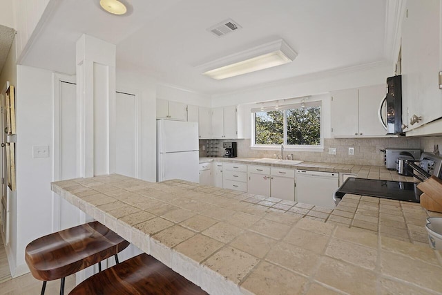 kitchen featuring white cabinets, white appliances, sink, and tasteful backsplash