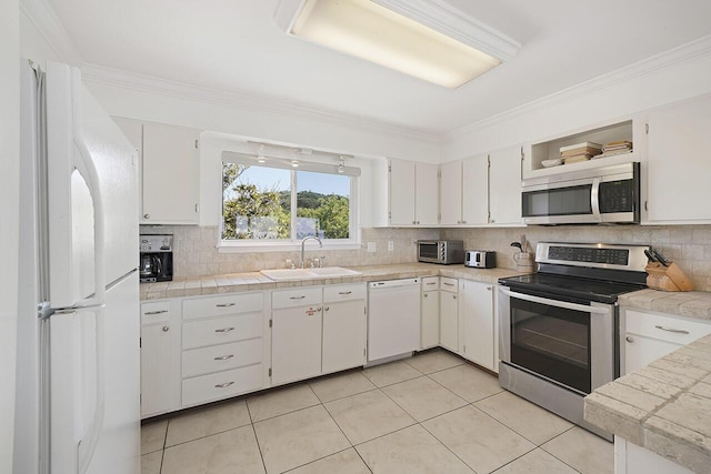 kitchen featuring backsplash, white cabinets, crown molding, sink, and appliances with stainless steel finishes