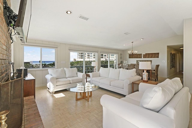 living room featuring a chandelier, a wealth of natural light, lofted ceiling, and parquet flooring