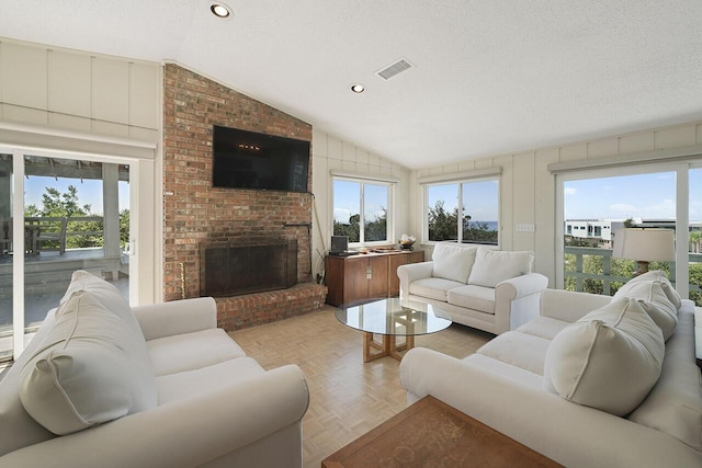 living room featuring a fireplace, light parquet floors, a textured ceiling, and vaulted ceiling