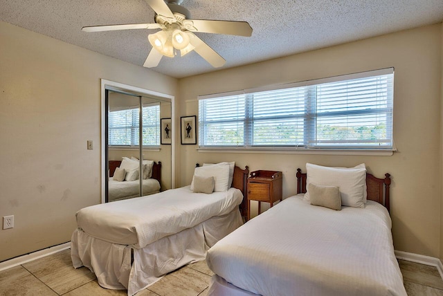 bedroom with multiple windows, a textured ceiling, a closet, and ceiling fan