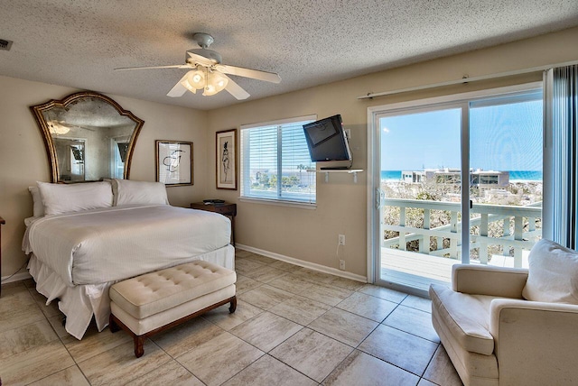 tiled bedroom with access to exterior, ceiling fan, and a textured ceiling