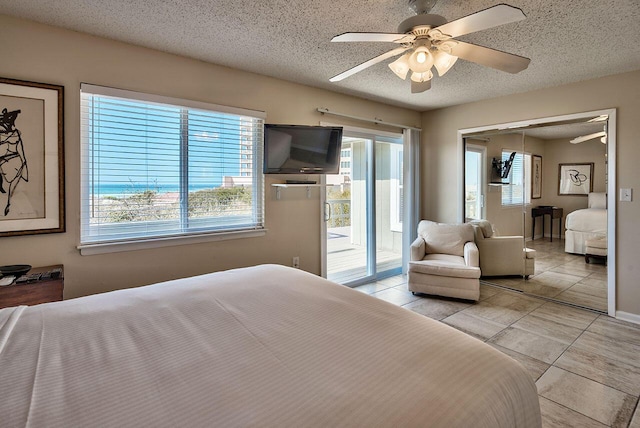 tiled bedroom with access to outside, ceiling fan, a closet, and a textured ceiling