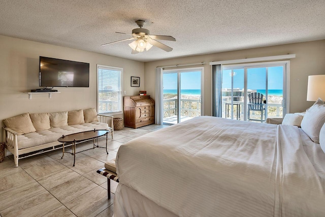 tiled bedroom featuring access to exterior, a textured ceiling, and ceiling fan