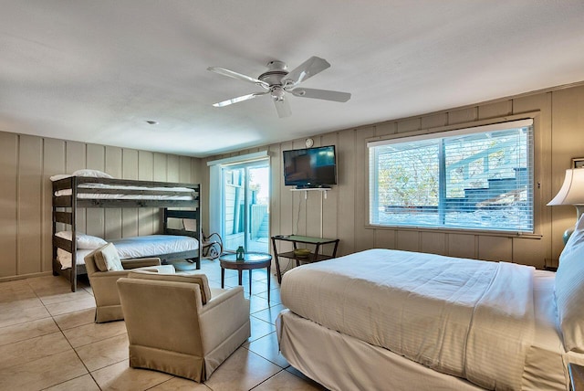 tiled bedroom featuring ceiling fan, a textured ceiling, and multiple windows