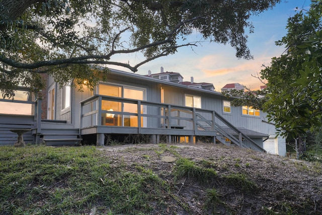 back house at dusk with a deck