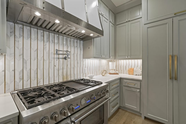 kitchen with gray cabinets, stainless steel range, and light wood-type flooring