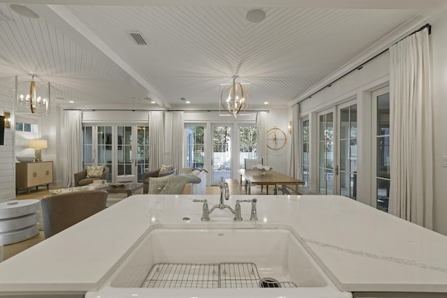 kitchen with french doors, pendant lighting, and a notable chandelier