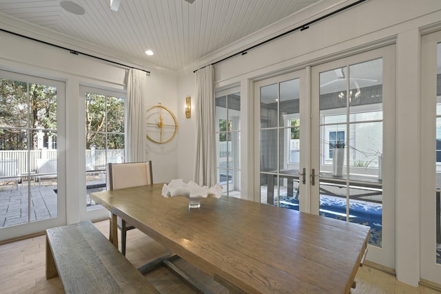 dining space featuring french doors, light wood-type flooring, and wood ceiling