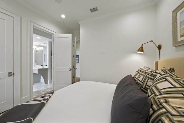 bedroom featuring a notable chandelier, ensuite bathroom, and crown molding