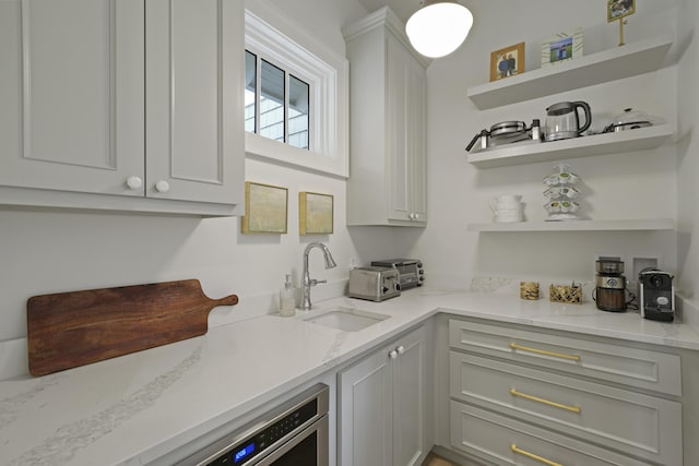 bar featuring light stone countertops and sink