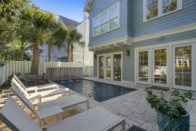 view of swimming pool with pool water feature and a patio area