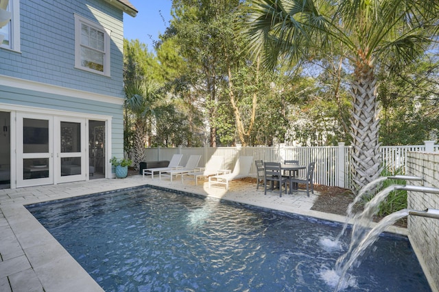 view of pool featuring a patio area, pool water feature, and french doors