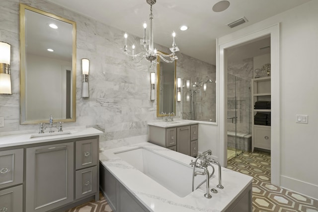 bathroom with a notable chandelier, vanity, tile walls, and plus walk in shower