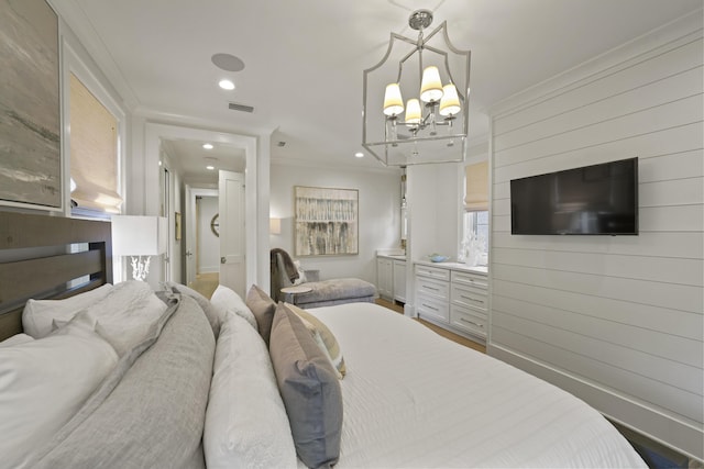 bedroom featuring a notable chandelier, wood-type flooring, and ornamental molding