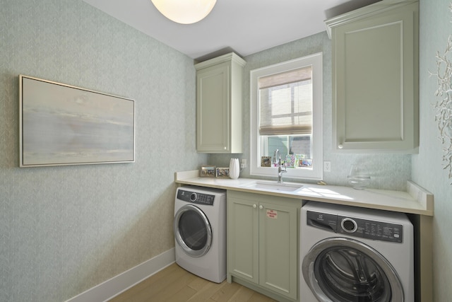 laundry area featuring cabinets, washer / dryer, light wood-type flooring, and sink