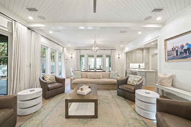 living room featuring light wood-type flooring, visible vents, and a wealth of natural light
