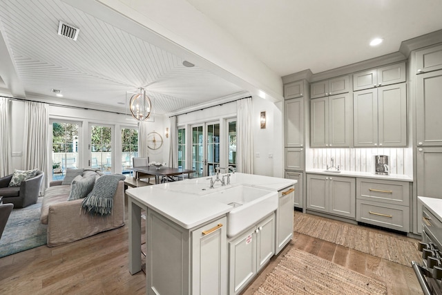 kitchen with open floor plan, light countertops, gray cabinetry, and a chandelier
