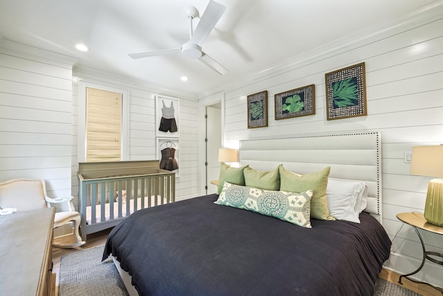 bedroom featuring wooden walls and crown molding